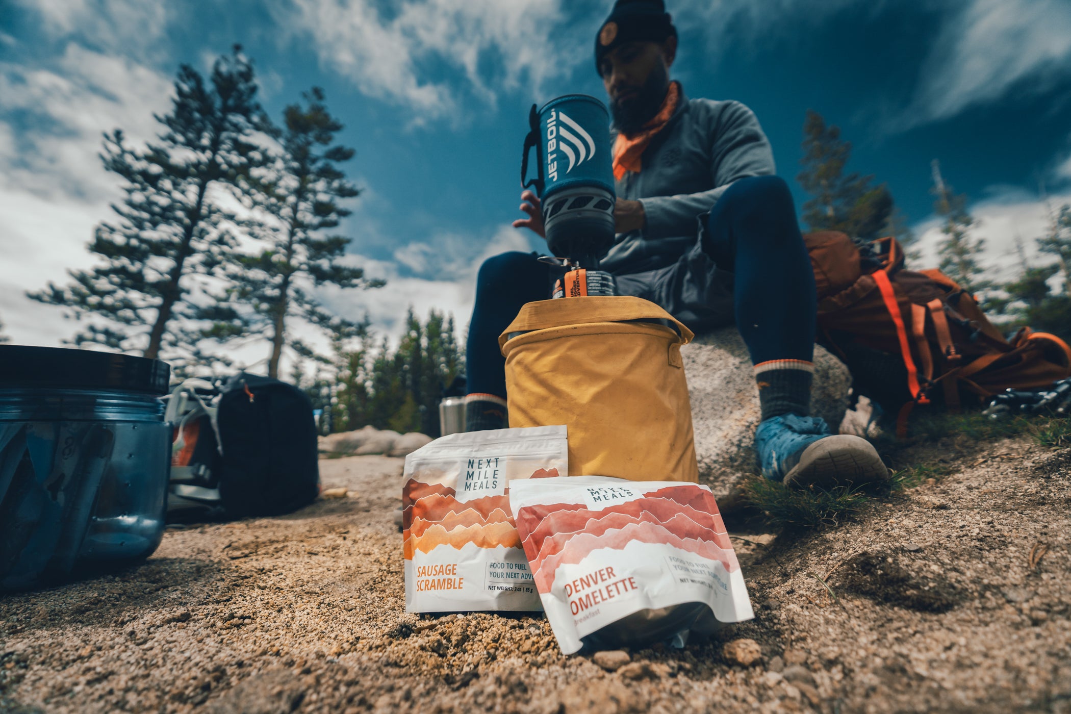 backpacker makes backpacking meals at camp